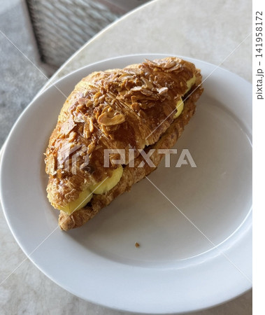 Freshly baked croissant, golden and flaky on the outside, soft and buttery on the inside. A perfect treat for breakfast or a light snack. 141958172