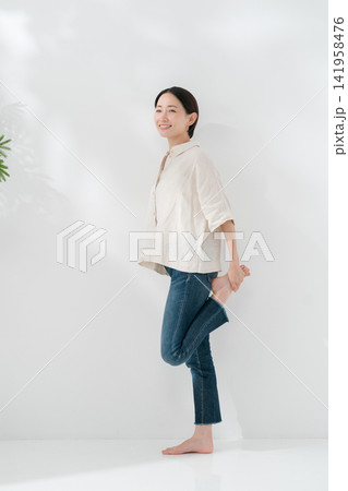 立って足のストレッチをする女性 立って足のストレッチをする女性 141958476