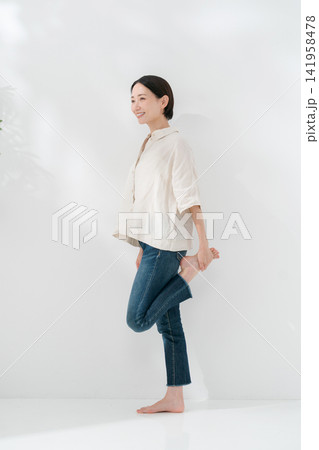 立って足のストレッチをする女性 立って足のストレッチをする女性 141958478