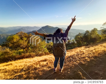 Freedom backpacker of Asian young woman spread her arms smiling happy on peak of mountains and mist in the morning with blue sky travel in Thailand Freedom backpacker of Asian young woman spread her arms smiling happy on peak of mountains and mist in the morning with blue sky travel in Thailand 141959783