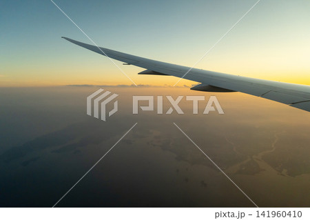 Airplane wing above Osaka coast during sunset descent flight Airplane wing above Osaka coast during sunset descent flight 141960410