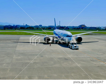トーイングカーに牽引されるANA旅客機と空港の青空 トーイングカーに牽引されるANA旅客機と空港の青空 141961847