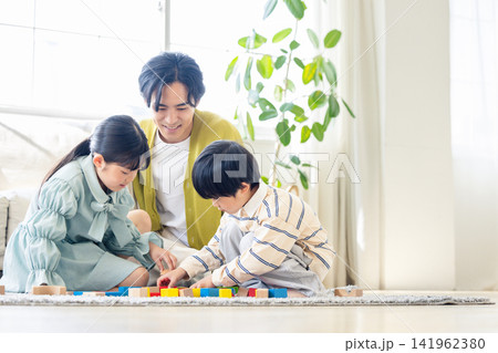 リビングで子供たちと積み木遊びを楽しむ父親 リビングで子供たちと積み木遊びを楽しむ父親 141962380