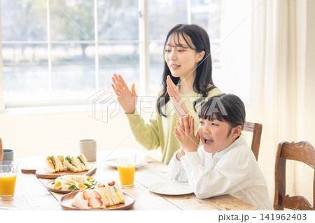 いただきますと手を合わせる母親と女の子 141962403