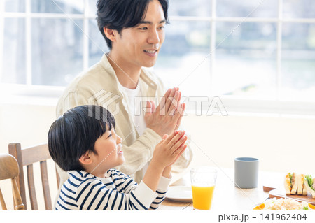 息子と一緒に手を合わせていただきますをする父親 息子と一緒に手を合わせていただきますをする父親 141962404