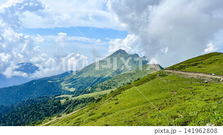 Scenic alpine mountain landscape with hiking trail and dramatic clouds Scenic alpine mountain landscape with hiking trail and dramatic clouds 141962808