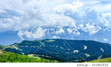 Panoramic mountain landscape with forested hills and dramatic clouds 141962810
