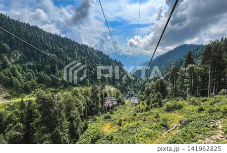Chairlift carrying passengers through the Caucasus mountain forest at Rosa Khutor, Sochi, Russia 141962825