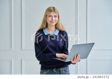 Portrait of teenage student girl holding a laptop Portrait of teenage student girl holding a laptop 141963172