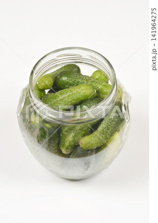 Open glass jar filled with green gherkin cucumbers 141964275