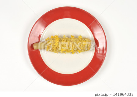 Eaten corn cob on a red plate from above 141964335