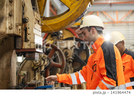 Male manufacturing in high visibility jacket and hard hat operator managing machine. Male manufacturing in high visibility jacket and hard hat operator managing machine. 141964474