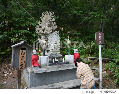 恐山の森に立つ不動明王像と参拝風景 恐山の森に立つ不動明王像と参拝風景 141964532