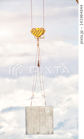 vertical photo of powerful crane hook lifting heavy concrete panel for panel house construction against bright cloudy sky, essential equipment in building industry development vertical photo of powerful crane hook lifting heavy concrete panel for panel house construction against bright cloudy sky, essential equipment in building industry development 141964844