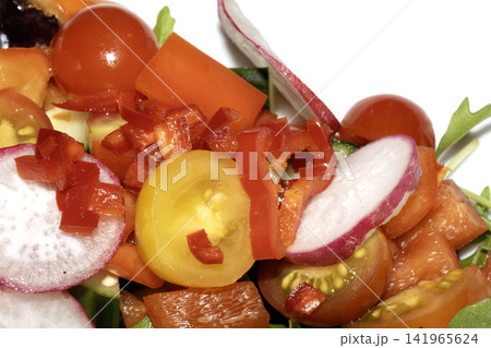 Close up of a delicious healthy side salad with leaves and radish on a white plate Close up of a delicious healthy side salad with leaves and radish on a white plate 141965624