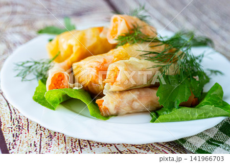 Korean pickled cabbage rolls stuffed with fresh carrot filling 141966703
