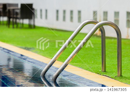 Ladder stainless handrails for descent into swimming pool. Swimming pool with handrail.  141967305