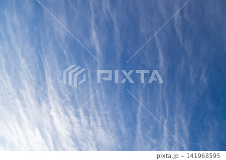 Wispy Cirrus Clouds Streaking Across a Bright Blue Sky Wispy Cirrus Clouds Streaking Across a Bright Blue Sky 141968595