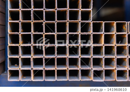 Close-Up of Stacked Square Metal Tubes with Rust Texture 141968610