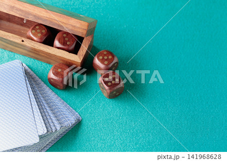 Playing cards and wooden dice on a green cloth. Playing cards and wooden dice on a green cloth. 141968628
