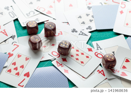 Playing cards and wooden dice on a green cloth. Playing cards and wooden dice on a green cloth. 141968636
