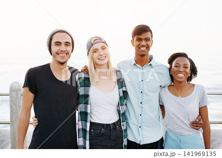 Friends, group and portrait on beach with hug for travel, bonding and happy outdoor on promenade. Diversity, gen z people and embrace by ocean for holiday, boardwalk and summer adventure in nature Friends, group and portrait on beach with hug for travel, bonding and happy outdoor on promenade. Diversity, gen z people and embrace by ocean for holiday, boardwalk and summer adventure in nature 141969135