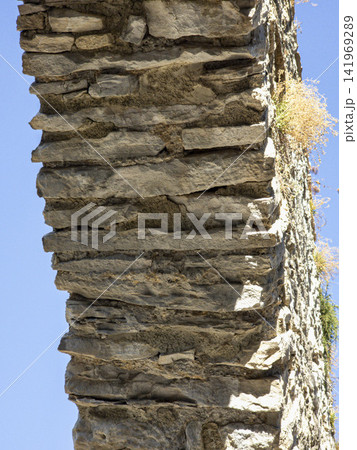 Close up view of stacked stones forming the soffit of a medieval aqueduct arch in bright sunlight Close up view of stacked stones forming the soffit of a medieval aqueduct arch in bright sunlight 141969289