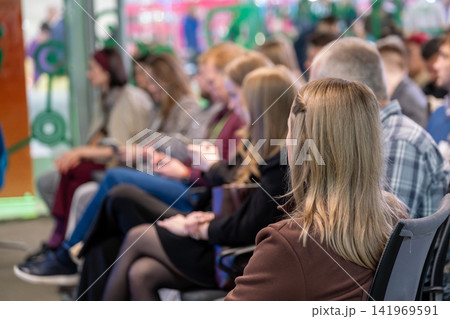 Woman listens among seated conference attendees Woman listens among seated conference attendees 141969591