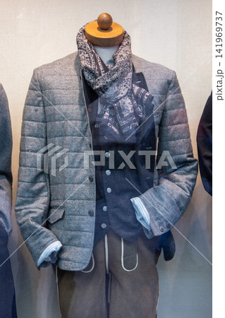 Menswear mannequin in quilted blazer and patterned scarf shop window 141969737