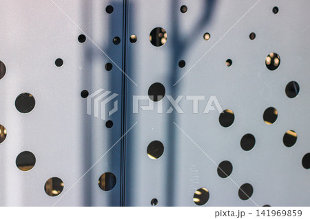 Abstract perforated metal wall texture with light and shadow pattern 141969859