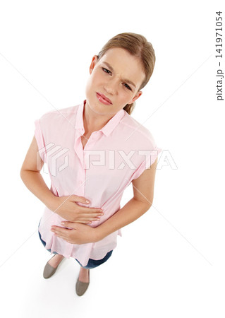 Portrait, woman and stomach ache in studio with pain, health issue and above. Sick, abdomen and face of isolated female person by white background for medical problem with cramps, gastro and hands Portrait, woman and stomach ache in studio with pain, health issue and above. Sick, abdomen and face of isolated female person by white background for medical problem with cramps, gastro and hands 141971054