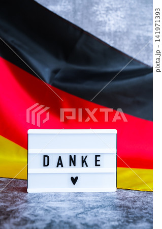 Lightbox with text DANKE THANK YOU National symbol of Germany. German wave silky flag background. thanksgiving day and gratitude Lightbox with text DANKE THANK YOU National symbol of Germany. German wave silky flag background. thanksgiving day and gratitude 141971393
