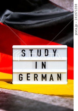 Lightbox with text STUDY IN GERMAN National symbol of Germany. German wave silky flag background. Education and learning Lightbox with text STUDY IN GERMAN National symbol of Germany. German wave silky flag background. Education and learning 141971394