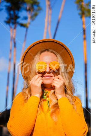 Woman close her eyes with yellow dahlia Autumn garden colorful flowers. Beautiful autumnal bouquet dahlia chrysanthemum. Red pink orange fall color fall floral background. Flower shop and florist Woman close her eyes with yellow dahlia Autumn garden colorful flowers. Beautiful autumnal bouquet dahlia chrysanthemum. Red pink orange fall color fall floral background. Flower shop and florist 141971395