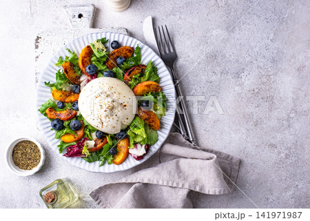 Salad with fresh burrata cheese, grilled peaches and blueberry 141971987