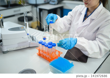 Female Scientist Handling Test Tubes in Modern Research Laboratory with Equipment 141972686