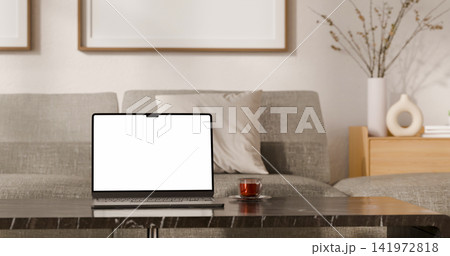 Laptop with Blank White Screen Mockup on Marble Table in Modern Living Room with Framed Wall Art 141972818