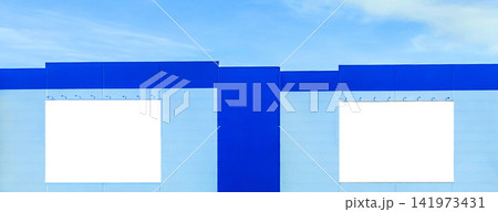 Mock up empty billboards on the modern facade of an urban building against a blue sky with clouds Mock up empty billboards on the modern facade of an urban building against a blue sky with clouds 141973431