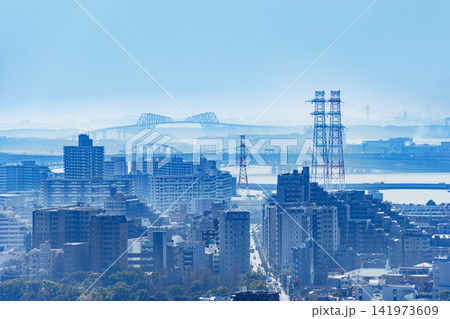 青く霞む湾岸風景と東京ゲートブリッジおよび送電鉄塔 141973609