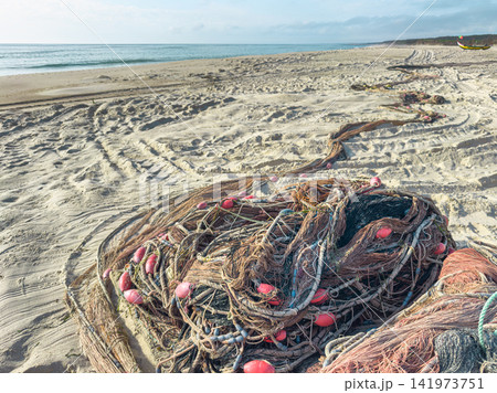 Traditional fishing nets spread on sandy ocean shore Traditional fishing nets spread on sandy ocean shore 141973751
