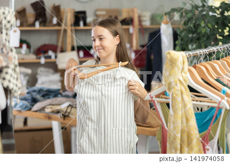 teenager chooses summer clothes in a store teenager chooses summer clothes in a store 141974058