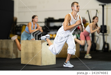 Athletic man in sportswear training his legs in gym 141974081