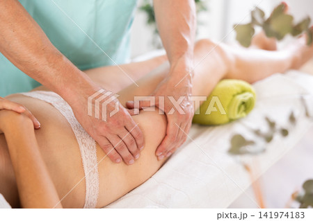 massage therapist doing a leg massage 141974183