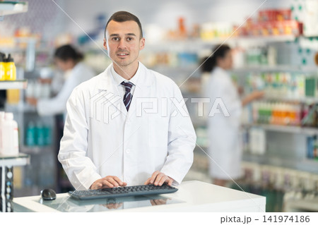 Portrait of friendly male pharmacist at the cash register in pharmacy 141974186