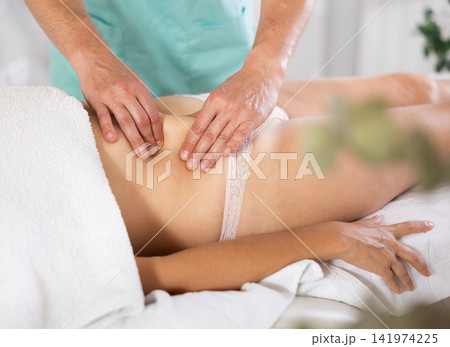The masseur makes a massage to a woman The masseur makes a massage to a woman 141974225
