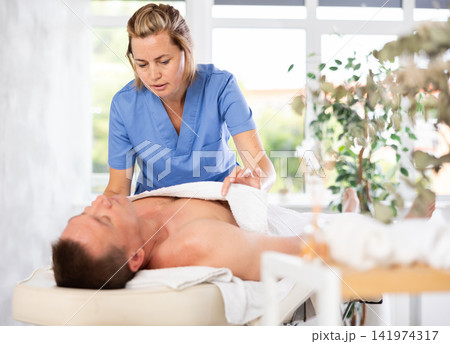 woman in the massage cabinet carefully places a towel woman in the massage cabinet carefully places a towel 141974317