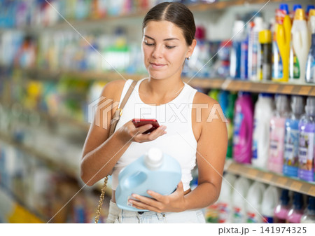 Young woman scanning qr code for laundry detergent 141974325