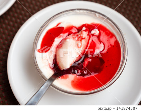 Delicate Italian Panna cotta topped with red cranberry sauce 141974387