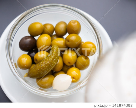 Bowl is filled with pickled vegetables - olives, small onions, gherkins Bowl is filled with pickled vegetables - olives, small onions, gherkins 141974398