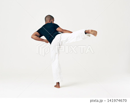 Man, studio and martial arts for kick practice, action and karate exercise on white background. Black male person, mockup space and training for combat, back and position of attack in taekwondo Man, studio and martial arts for kick practice, action and karate exercise on white background. Black male person, mockup space and training for combat, back and position of attack in taekwondo 141974670